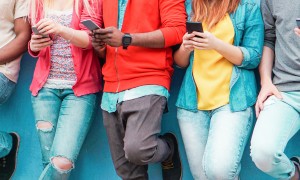 A group of young people are browsing on their mobile phones.